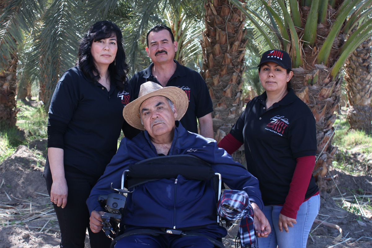 Enrique Bautista, owner of the Bautista Family Date Ranch, sits in front of his children Alicia (L), Alvaro (middle), and Maricela (R).